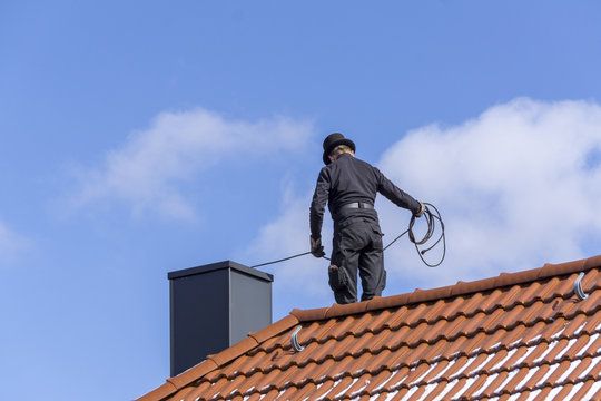 Sweep walking a tiled ridge with line coiled in hand